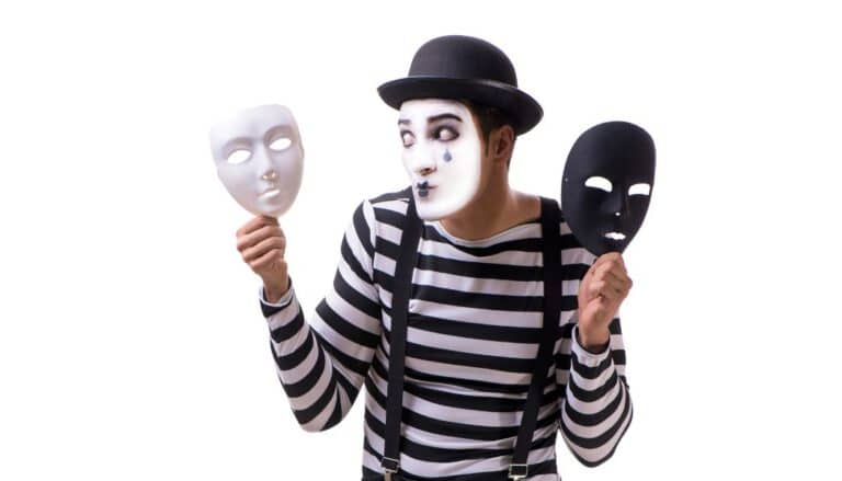 Mann hält zwei Masken in der Hand: Vermeider oder Narzisst?