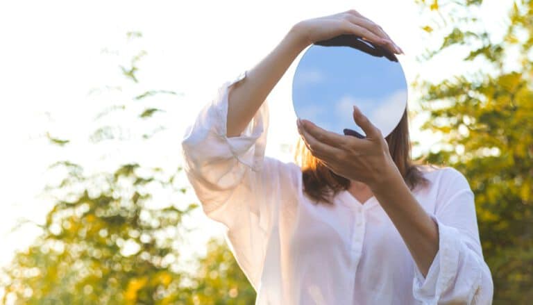 Partner als Spiegel - Frau hält Spiegel vors Gesicht